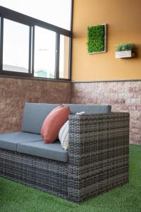 wiklinowa kanapa siedząca w pokoju z trawą w obiekcie Bellavista Aeropuerto w mieście Aguatona