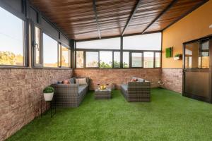 an outdoor living room with a brick wall and green grass at Bellavista Aeropuerto in Aguatona