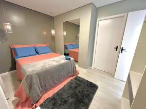 a bedroom with a bed with blue and orange pillows at Hotel Manaus - Dom Pedro I in Manaus