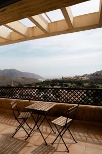 Una mesa y sillas en un balcón con vista. en Suite La Envía Golf, en Almería
