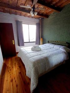 a bedroom with a large bed and a window at Posada San Gabriel in Colonia del Sacramento