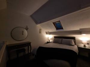 a bedroom with a bed with two lamps and a mirror at Cosy Moat House Cottage #6 in Pembroke