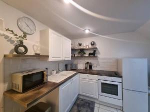 a kitchen with white cabinets and a microwave on a counter at Cosy Moat House Cottage #6 in Pembroke