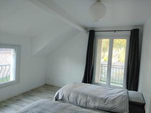 ein Schlafzimmer mit einem Bett und einem großen Fenster in der Unterkunft Maison 10 couchages secteur Fontainebleau in Vernou-sur-Seine