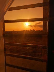 Blick auf den Sonnenuntergang durch ein Fenster in der Unterkunft Appartement meublé 2 pièces rez de chaussée, Résidence Nehemie in Abidjan