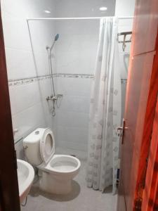 a white bathroom with a toilet and a shower at Résidence Néhémie in Abidjan