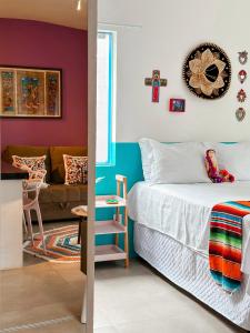a bedroom with a bed and a living room at Vila Real Apartamentos in Itacaré +20 photos