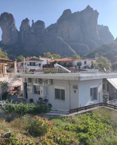 a white house with a mountain in the background at Nikos, Old Kalabaka Apartment in Kalabaka