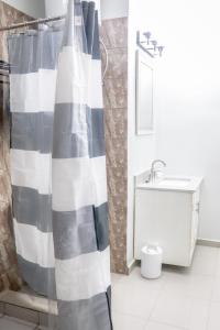 ein Bad mit einem schwarzen und weißen Duschvorhang in der Unterkunft MARIBART RESIDENCE - Électricité inclus, Forage in Jaunde