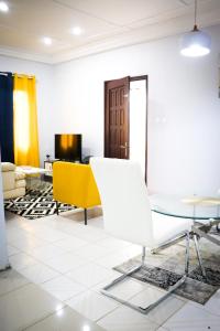 un soggiorno con tavolo e sedia gialla di MARIBART RESIDENCE - Électricité inclus, Forage a Yaoundé