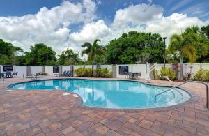 basen na ceglanym patio ze stołami i krzesłami w obiekcie Hampton Inn & Suites Tampa Northwest/Oldsmar w mieście Oldsmar