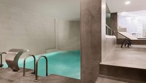 a swimming pool in the middle of a room at NH Valencia Las Artes in Valencia
