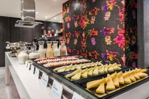 una línea de buffet con queso y otros productos alimenticios en NH Bogota Urban 26 Royal, en Bogotá