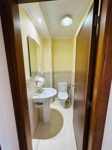 a bathroom with a sink and a toilet and a mirror at appartement de vacances achakar avec plage&piscine in Tangier