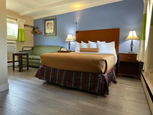 ClaremontにあるClaremont Motor Lodgeのベッドとソファ付きのホテルルーム