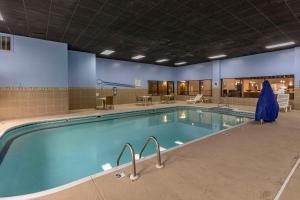 uma grande piscina numa grande sala com mesas e cadeiras em Comfort Inn Collinsville near St Louis em Collinsville