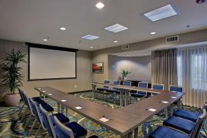 a conference room with tables and chairs and a screen at Holiday Inn Express & Suites Costa Mesa, an IHG Hotel in Costa Mesa