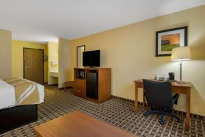 a hotel room with a bed and a desk with a computer at Quality Inn Ashland in Ashland