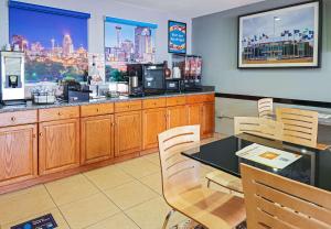 um restaurante com mesa e cadeiras e uma cozinha em Rodeway Inn San Antonio Lackland AFB - SeaWorld em San Antonio
