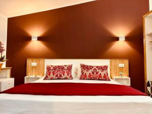 Un dormitorio con una cama grande con almohadas rojas. en B&B THE SUN - Family Rooms, en Tropea