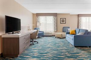 um quarto de hotel com uma televisão de ecrã plano e mobiliário em Comfort Inn & Suites Greenville Near Convention Center em Greenville