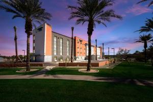 a building with palm trees in front of it at WoodSpring Suites Chandler Airport in Chandler