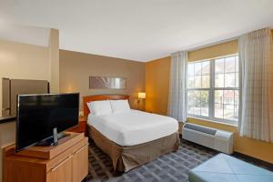 a hotel room with a bed and a flat screen tv at MainStay Suites Mt Laurel - Philadelphia in Mount Laurel