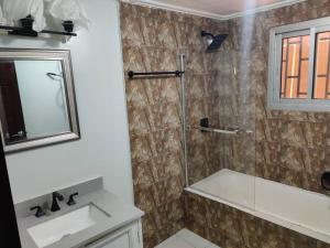 a bathroom with a shower and a sink and a mirror at MARIBART RESIDENCE - Électricité inclus, Forage in Yaoundé