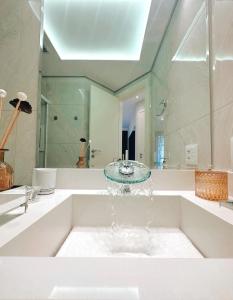 a bathroom with a bath tub with a sink at Moema Times Square SP - Luxury Suíte in São Paulo