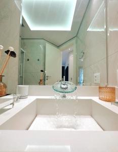 uma casa de banho com banheira e lavatório em Moema Times Square SP - Luxury Suíte em São Paulo