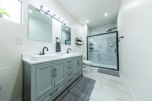 a white bathroom with a sink and a shower at 8 Beds Home with 4 Car Parking Space - Near DTLB in Long Beach