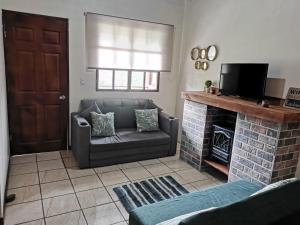 a living room with a couch and a fireplace at Cabaña Vista Verde in Cartago