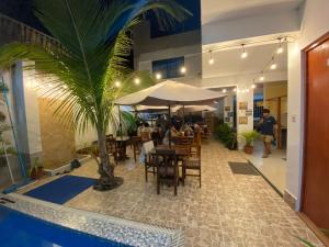 a restaurant with a table and chairs and a palm tree at Hospedaje Ola Marina in Máncora