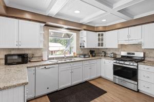 a white kitchen with white cabinets and a window at Paramount Paradise in Big Bear Lake
