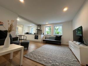 a living room with a couch and a tv at Modernes Apartment mit eigener Terrasse & Garten in Aalen
