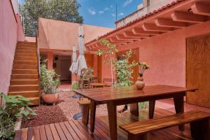 een patio met een houten tafel en een bank bij Hotel Materia in Oaxaca City