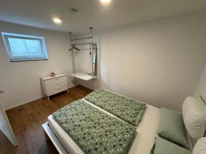 Habitación pequeña con cama y ventana en Modernes Apartment mit eigener Terrasse & Garten, en Aalen