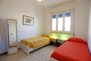 ein Schlafzimmer mit zwei Betten und einem Spiegel in der Unterkunft Ulisse apartment on the sea in Punta Secca