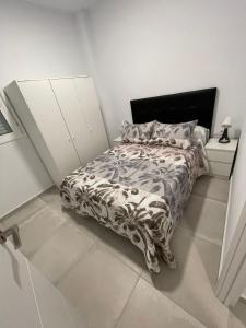 a bedroom with a bed with a black and white comforter at La Meridian II in Barcelona