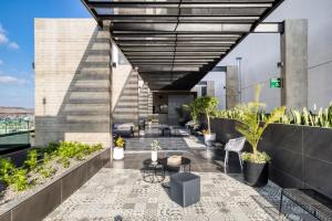 an outdoor patio with tables and chairs on a building at Downtown Loft by ULIV in Tijuana