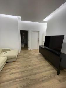 un soggiorno con divano e TV a schermo piatto di La Meridian II a Barcellona