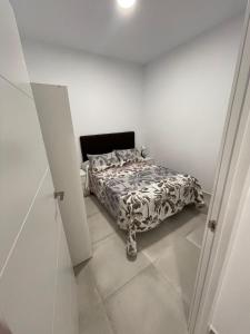 um quarto com uma cama num quarto branco em La Meridian II em Barcelona