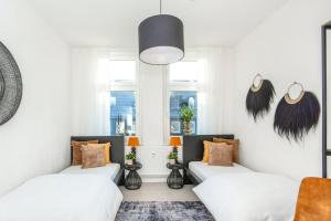 un soggiorno con 2 letti e una luce a ciondolo di FourSolos Apartment in Central Essen a Essen