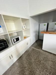 a kitchen with white cabinets and a counter at Don Enrique Bar&Hostel in San Gregorio