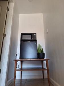 a microwave sitting on a wooden table with a plant at Garden motel in Redwood City