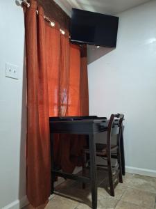 a desk with a television in a room with a curtain at Garden motel in Redwood City