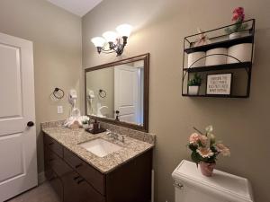 La salle de bains est pourvue d'un lavabo, d'un miroir et de toilettes. dans l'établissement MyCrib Houston Hostel, à Houston