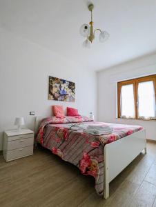 a white bedroom with a bed with pink pillows at I Due Ciliegi in Abbadia San Salvatore