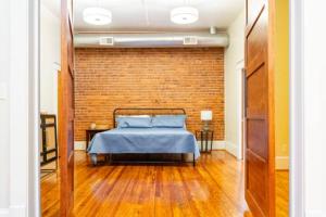 a bedroom with a bed and a brick wall at The Marilyn Monroe Loft. Central Downtown Location in Roanoke