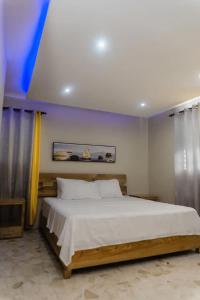 a bedroom with a large bed with yellow curtains at Verde Bonavita in Santiago de los Caballeros